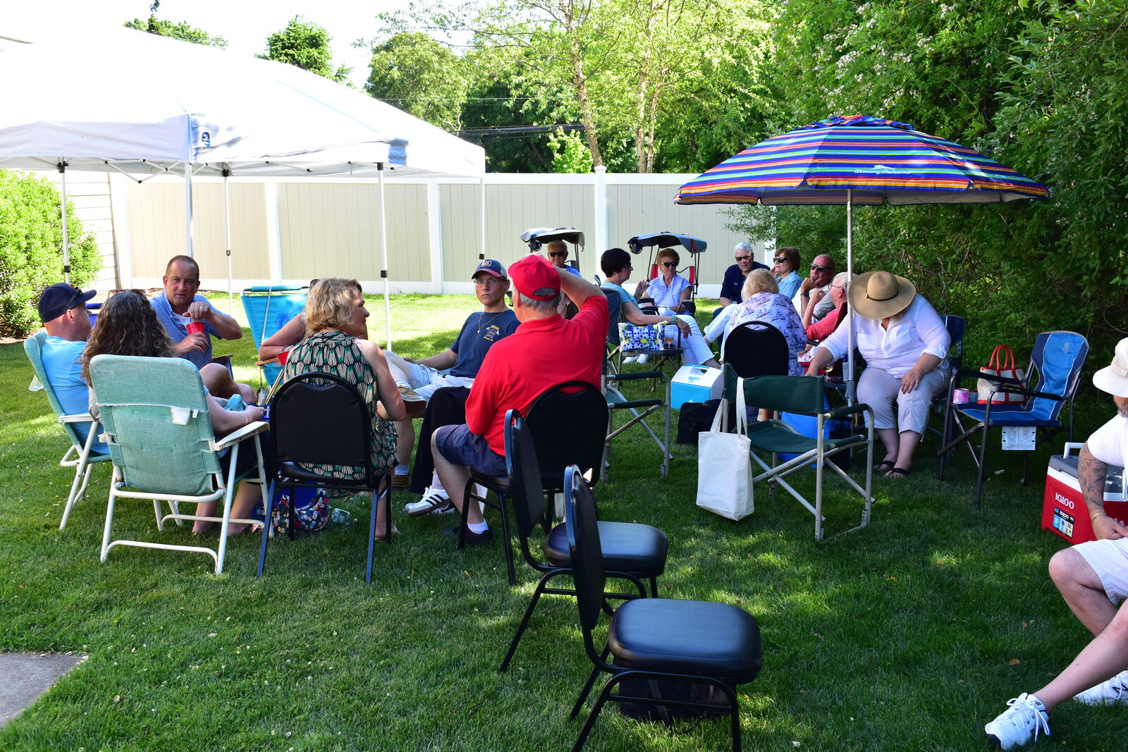 Guests gathered under a canopy and umbrella for fellowship