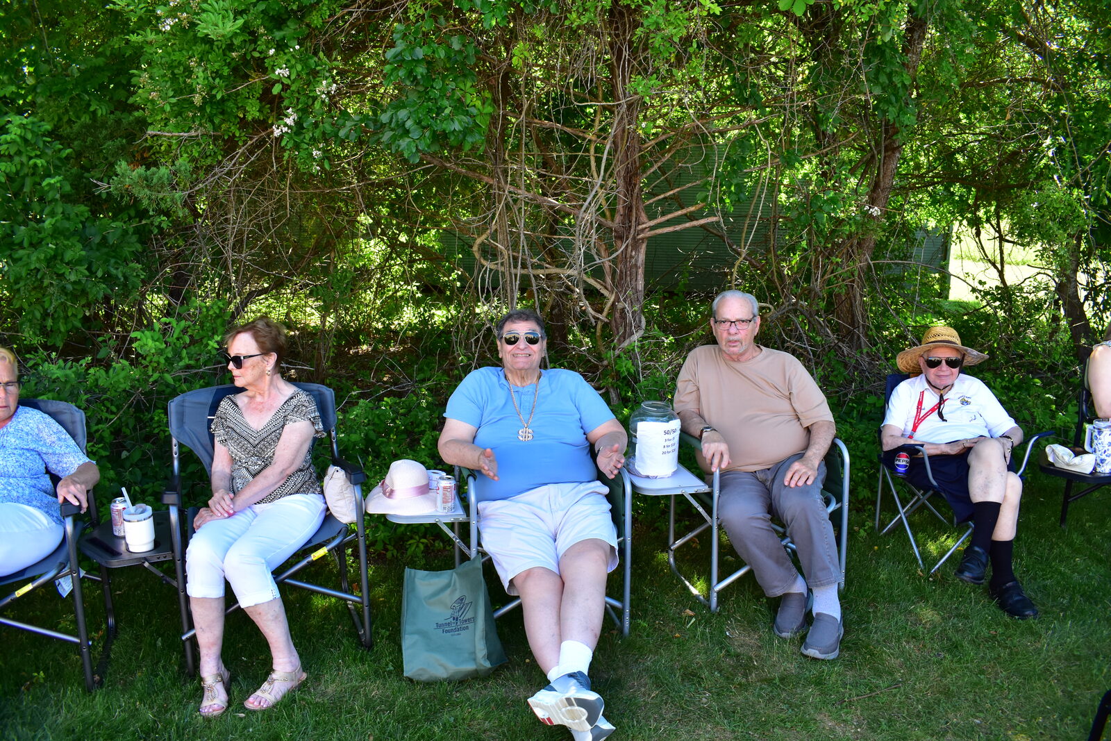 Parish community relaxing in folding chairs in the shade