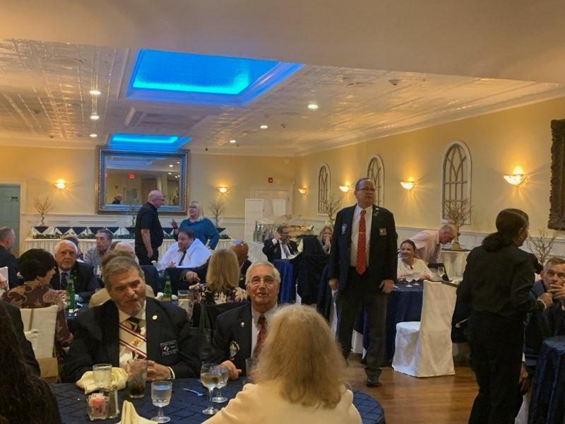 Guests seated for the Officer Installation dinner in a banquet hall with blue table linens