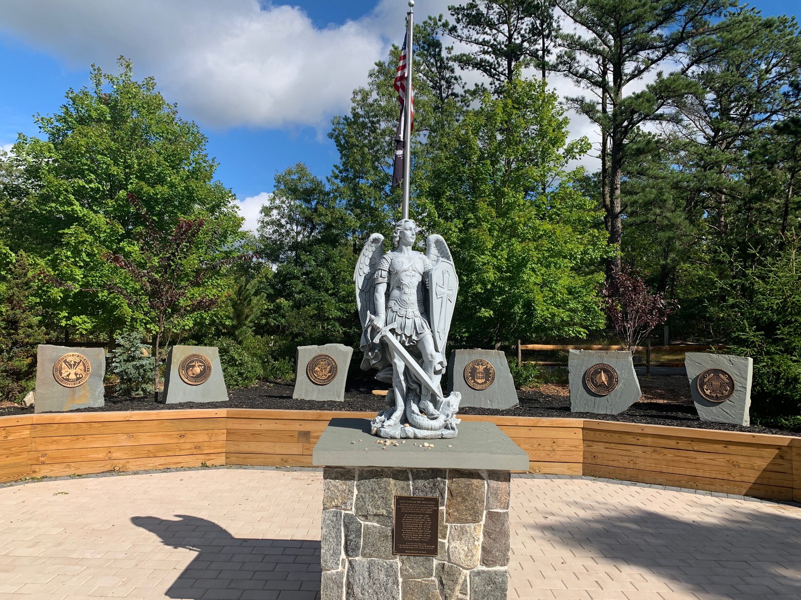 St. Michael the Archangel statue in the Armed Forces Prayer Garden, surrounded by stones bearing the emblems of the military branches